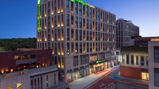 A multi-story hotel with a modern architectural design, featuring a prominent Holiday Inn Express sign.