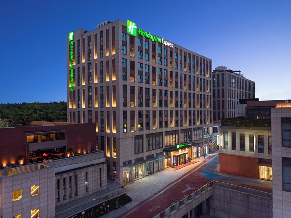 A multi-story hotel with a modern architectural design, featuring a prominent Holiday Inn Express sign.