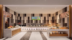 A modern buffet setup with multiple food stations and a central serving area.