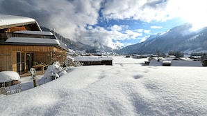 A snow-covered mountain village with wooden buildings, a wooden deck, and a clear sky. - MAC's Apartment - MAC's Apartment (Au)