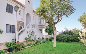 Traditional Mediterranean-style building with a central staircase and well-maintained garden.