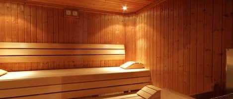 Un sauna en bois avec des bancs, et un banc situé à droite.