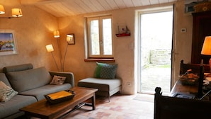 Un salón acogedor con un sofá, una mesa de centro de madera y una ventana con vistas al exterior.