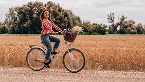 A person riding a bicycle with a basket on a dirt path through a field. - Ibis budget Stein Maastricht (Stein)