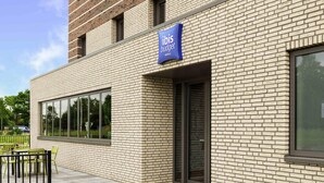 A modern hotel building with a prominent sign for ibis budget hotels. - Ibis budget Stein Maastricht (Stein)