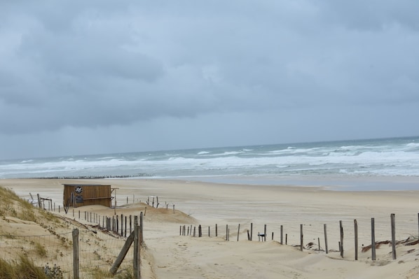 Une plage avec un poste de surveillance pour les sauveteurs et une clôture en bois.