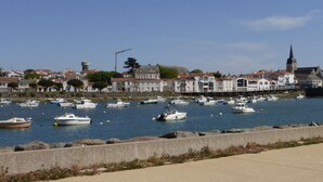 A harbor with boats docked, a water tower, and buildings with red roofs.
