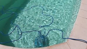 Ein Schwimmbecken mit klarem Wasser und einem Schlauch darin.