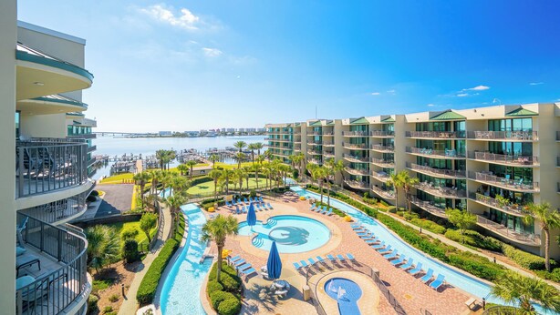 Un hôtel doté d’une piscine, de plusieurs balcons et offrant une vue sur l’eau.