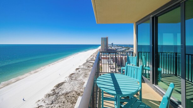A balcony with a view of a beach and ocean.