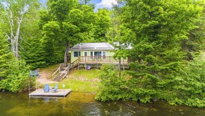 A lakeside cabin with a dock, surrounded by dense greenery. - Lakefront 3 Bedroom Cottage - sleeps 6 (Harcourt)