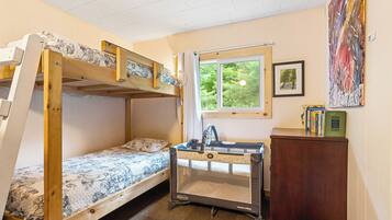 Cozy retreat with a bunk bed, desk, and bookshelf, offering a peaceful space for work or relaxation.