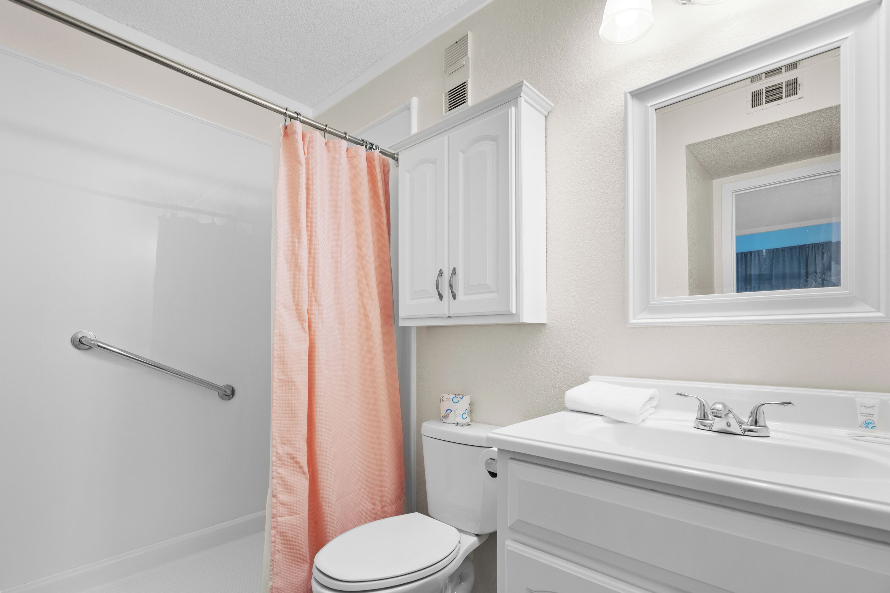 A bathroom with a shower, toilet, and sink.