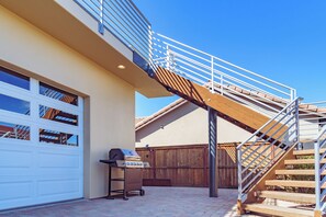 A residential garage with a wooden staircase leading to a second floor.