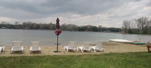 Relax by the lake with comfortable lounge chairs and a shaded area.