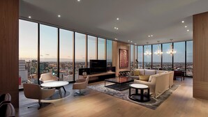 A spacious living room with a large TV, comfortable seating, and a city view. - The Westin Perth (Perth)