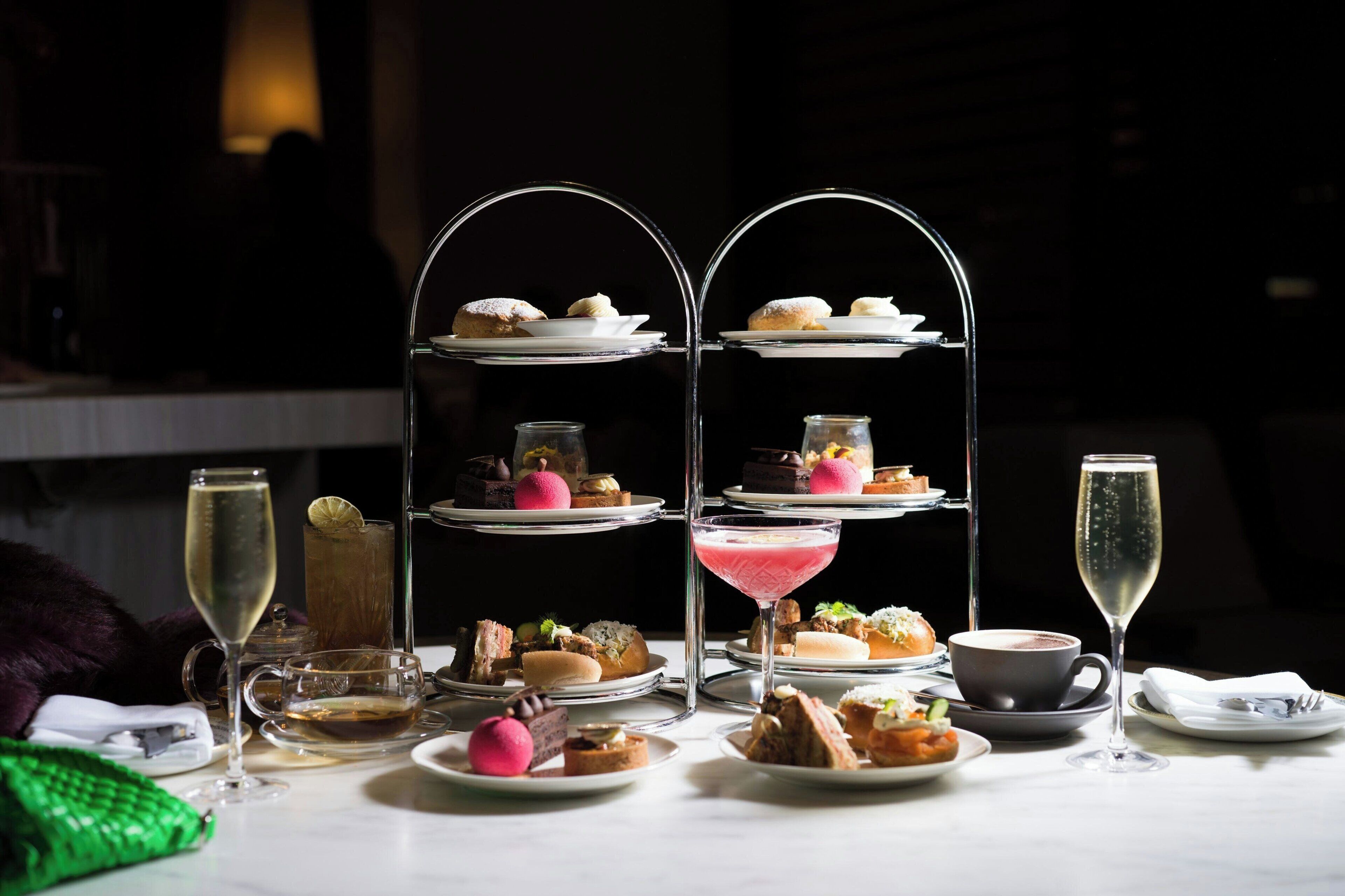 A dessert display with multiple tiers, a martini glass, and a cup of coffee.