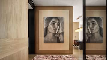Un interior moderno con paneles de madera, un cuadro abstracto grande y una alfombra estampada.