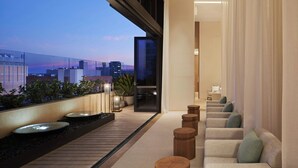 A modern interior with a seating area, a view of the cityscape, and a balcony with plants. - The Westin Perth (Perth)