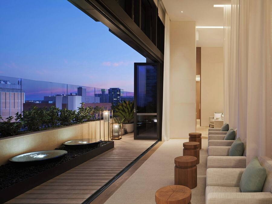 Un intérieur moderne avec un coin salon, une vue sur le paysage urbain et un balcon agrémenté de plantes.