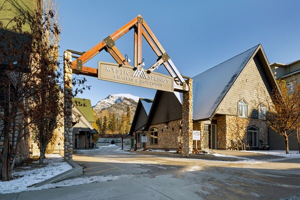 A stone building with a sign reading "Mystic Springs Chalets & Hot Pools".