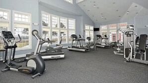 Ein Fitnessstudio mit Laufbändern, Crosstrainern und Krafttrainingsgeräten.