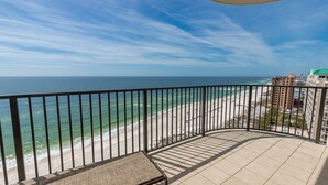 Un balcon avec vue sur une plage et l’océan.