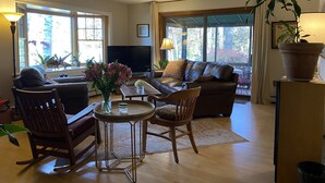 A living room with a sofa, chairs, a coffee table, a TV, and large windows. - 600' of Waterfront Chauncey Creek House, fenced yard, office, walk to the beach (Kittery)