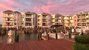 Un edificio residencial frente al agua, con varios balcones y una zona de embarcadero con barcos.