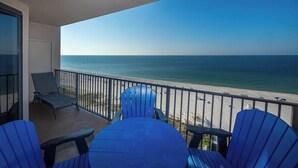 A balcony with a view of the ocean, featuring a table and chairs. - Phoenix X 2BR Condo on the 9th floor (Orange Beach)
