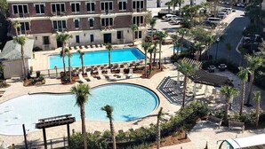Ett semesterhotell med en stor pool, flera avslappningsområden och utsikt över det omgivande området.