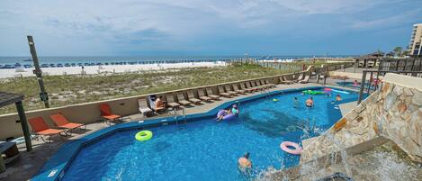 Relax by the pool at Phoenix III with a relaxing waterfall and beachfront view, perfect for family fun and sun-soaked days