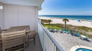 Un balcon avec vue sur une plage et une piscine.