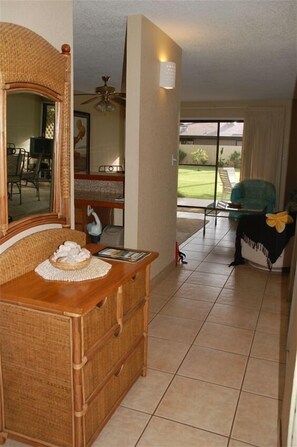 A living room with a wicker furniture set, a glass coffee table, and a view of the outdoors. - THE BEST KEPT SECRET ON MAUI !!!  LITTLE PEACE OF PARADISE  (Kihei)