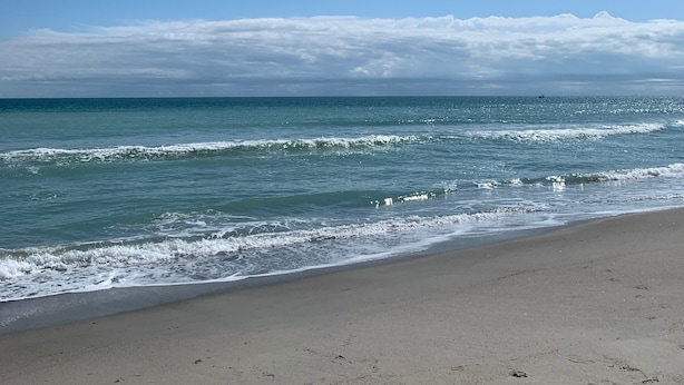 A beach with clear skies and calm waves.