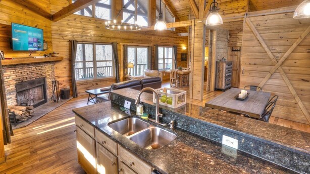 A spacious log cabin interior with a kitchen, dining area, and living room. - Allure Cabin – Family-Friendly Escape w/ Fire Pit, Creek & Near Helen! (Cleveland)