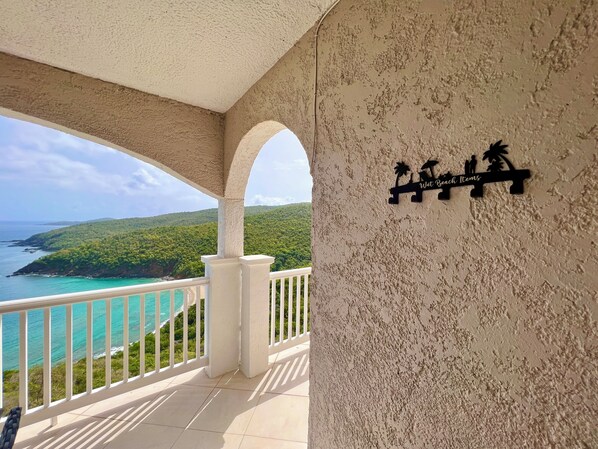 Un balcón con vista al océano y un cartel que dice 'Wet Beach Items'.