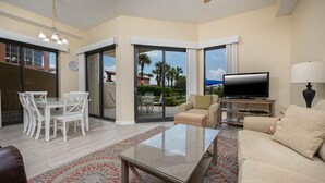 A spacious living room with a TV, sofa, and dining area. - GROUND FLOOR! 3 Bedroom! Phoenix East II - Splash Pad (Orange Beach)