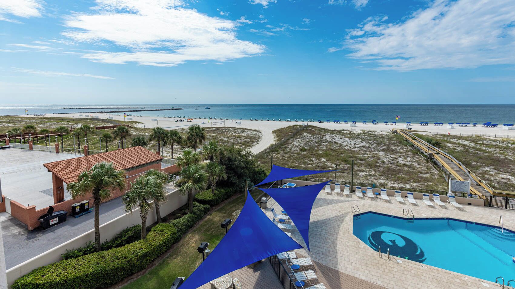 A resort with a swimming pool, beach access, and a view of the ocean.
