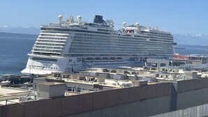 Ein großes Kreuzfahrtschiff liegt in einem Hafen, mit mehreren Decks und Kabinen.