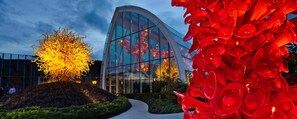 A modern building with a curved glass facade and a sculpture garden with abstract glass art. - Downtown, 2 BR, WATER VIEW, 98% Walk Score! FREE Pkg, Pool, hot tub, weight room (Seattle)