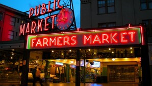 Ein Bauernmarkt mit einer Uhr und Neonreklamen.