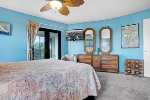 Une chambre à coucher avec un grand lit, une commode en bois, un téléviseur et une carte accrochée au mur.