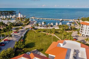 A marina with boats docked, a lighthouse, and a building with a red roof. - M18 - Spacious 3 bedroom, 2 bath Gulf side condo! (Marathon)