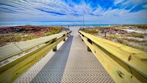 A wooden boardwalk leading to a beach with a clear sky. - See why this condo is in High Demand! 3BR 2BA @ Phoenix 8! (Orange Beach)