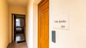 Un couloir avec une porte en bois et une pancarte sur laquelle on peut lire : « Villa Ephélias ».