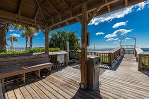A wooden deck with benches, a trash can, and a no-smoking sign. - 2 BR @ Seaside Beach & Racquet (Orange Beach)