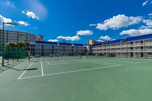 A tennis court with a net in the middle, surrounded by a fence. There are multiple tennis courts visible. - 2 BR @ Seaside Beach & Racquet (Orange Beach)