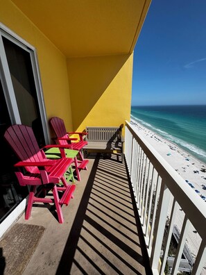 Un balcon avec vue sur la plage, comprenant une table et des chaises.
