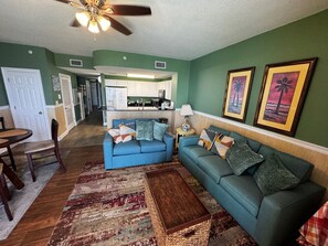 A living room with a blue sofa, a coffee table, and a patterned rug.